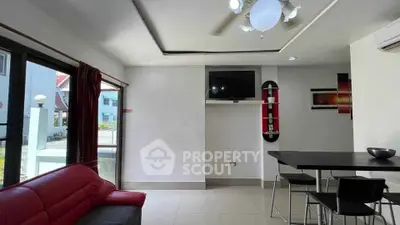 Modern living room with red sofa and wall-mounted TV in a bright interior.