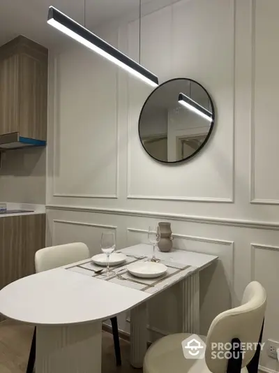 Modern dining area with elegant round mirror and stylish lighting