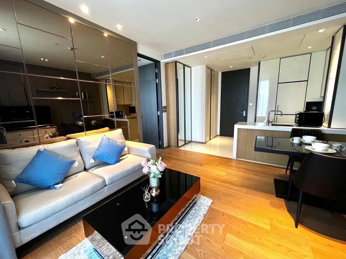 Modern open-plan living room with sleek kitchen, stylish decor, and wooden flooring in luxury apartment.