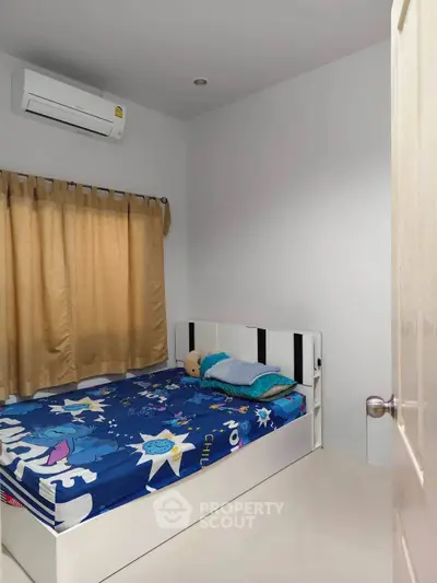 Cozy bedroom with air conditioning and colorful bedding, perfect for a restful night's sleep.