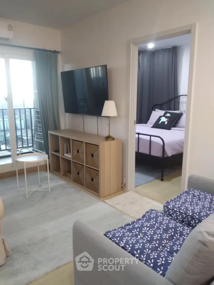 Modern apartment living room with TV and view into cozy bedroom