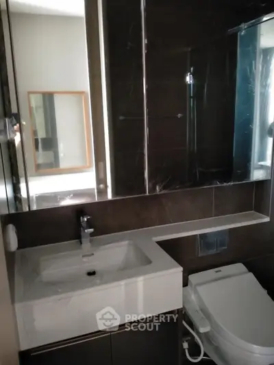 Modern bathroom with sleek fixtures and large mirror in a contemporary apartment.