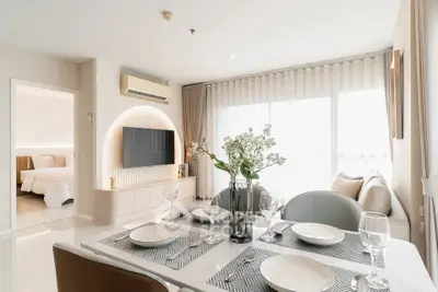 Modern living room with dining area, stylish decor, and natural light, perfect for contemporary living.