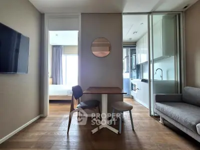 Modern apartment interior with open layout, featuring a cozy living area, dining space, and sleek kitchen.
