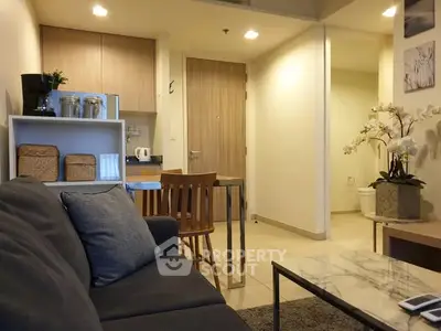 Modern open-concept living room with cozy seating and stylish kitchen area.