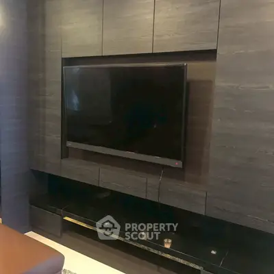 Modern living room with sleek wall-mounted TV and dark wood paneling.