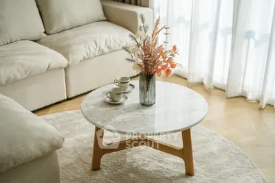 Elegant living room with cozy sofa and stylish marble coffee table in natural light.