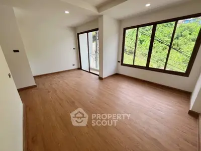 Spacious corner unit with large windows and wooden flooring, offering abundant natural light and serene views.