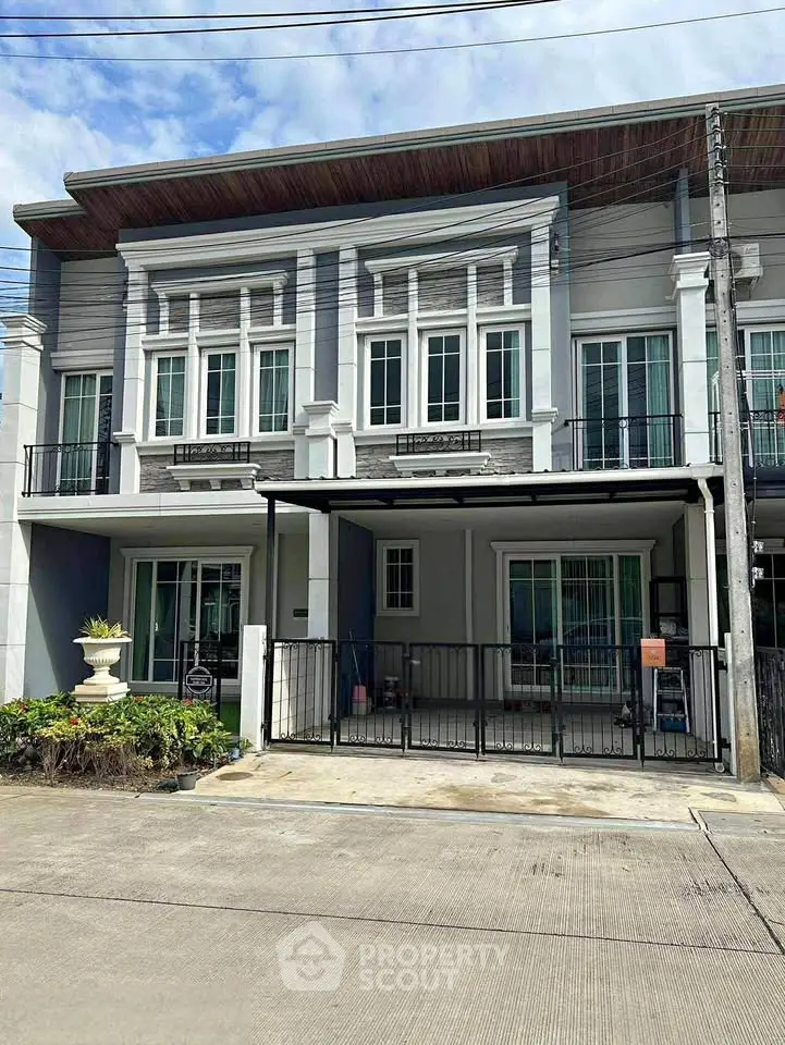 Modern two-story townhouse with elegant facade and spacious driveway