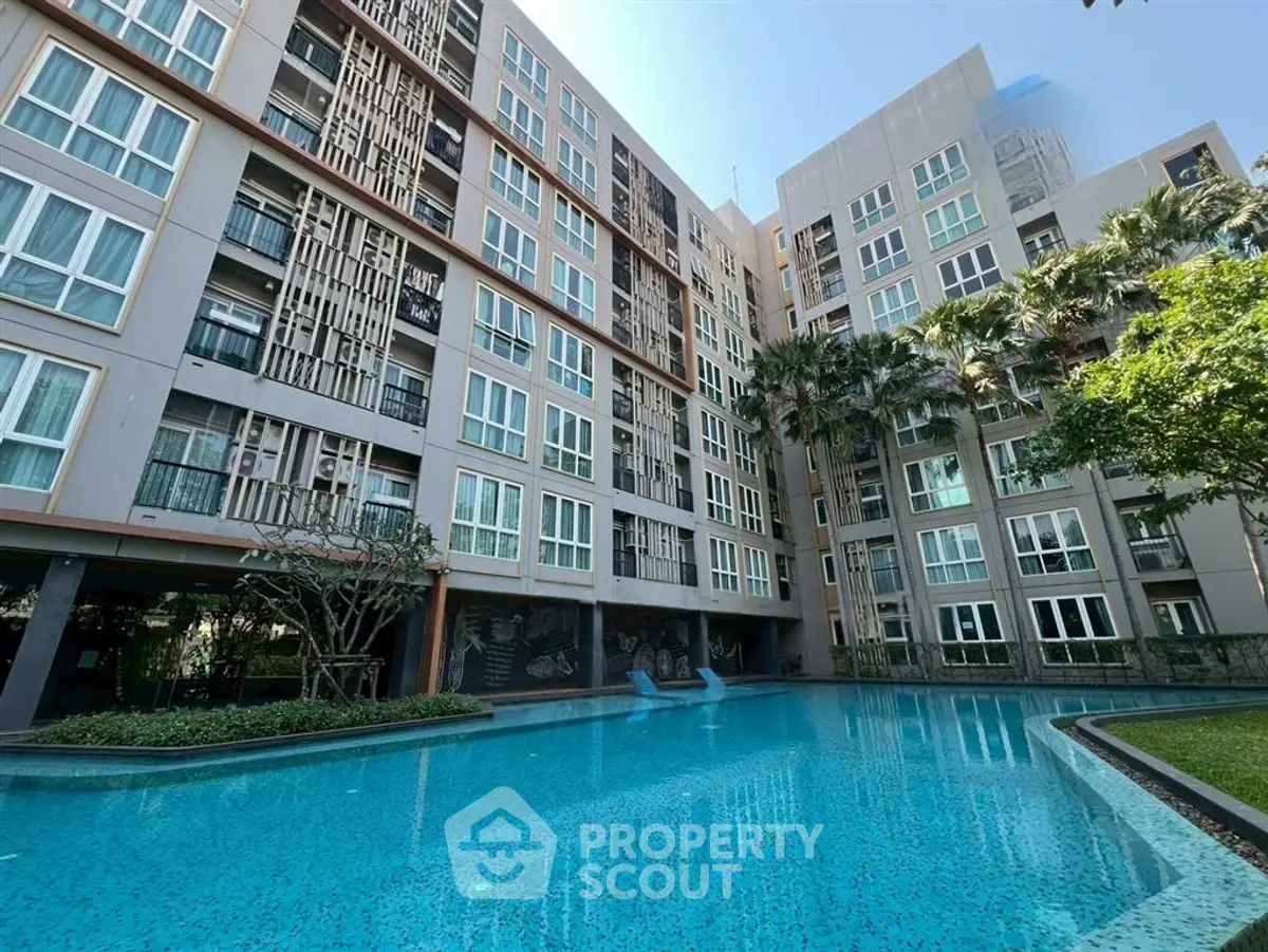 Modern condominium with a stunning pool and lush greenery, perfect for luxury living.