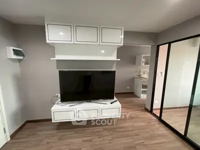 Modern living room with sleek TV setup and stylish cabinetry in a contemporary apartment.
