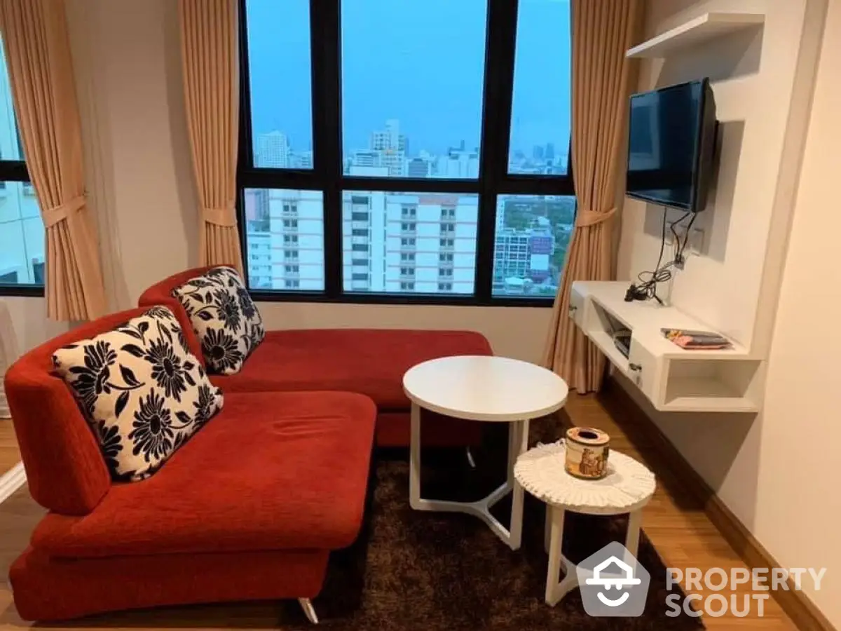 Cozy living room with red sofa and city view from large windows