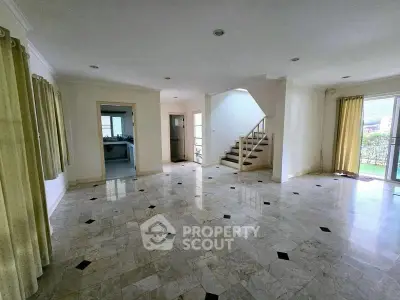 Spacious open-plan living room with marble flooring and natural light