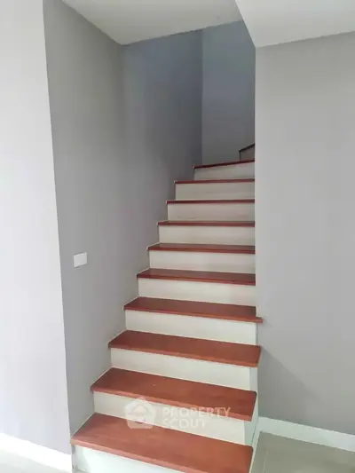 Modern staircase with wooden steps and minimalist design in a contemporary home.