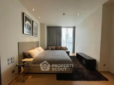 Modern bedroom with cozy bed, stylish decor, and large window offering natural light.