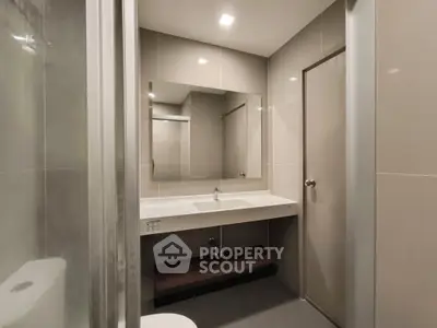 Modern bathroom with sleek design and large mirror in a contemporary apartment.