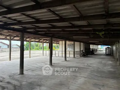 Spacious industrial warehouse with open layout and sturdy metal roofing, ideal for storage or manufacturing.