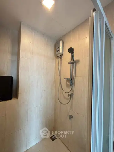 Modern bathroom with sleek shower and water heater in a stylish real estate property.