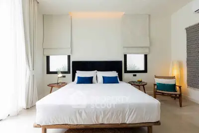 Luxurious bedroom with modern decor and natural light, featuring a plush bed and stylish furnishings.