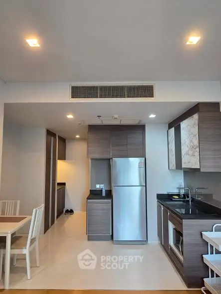 Modern kitchen with sleek cabinetry and stainless steel appliances in a stylish apartment.