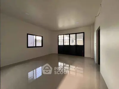 Spacious empty room with large windows and glossy tiled floor