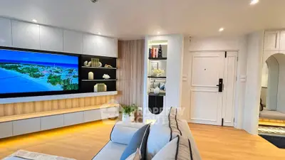 Modern living room with sleek design, large TV, and stylish shelving, perfect for contemporary living.