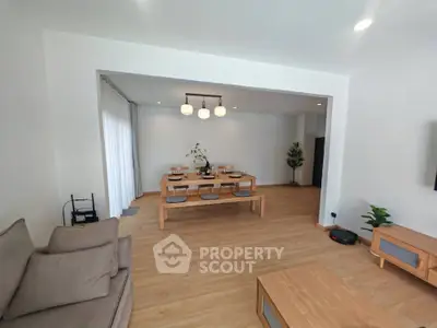 Spacious living room with modern wooden furniture and elegant dining area.