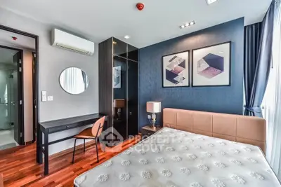 Modern bedroom with stylish decor, featuring a comfortable bed, elegant artwork, and a sleek vanity desk.