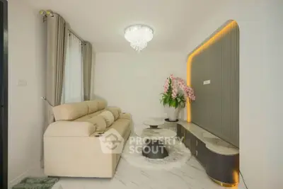 Elegant living room with plush sofa, modern chandelier, and stylish decor