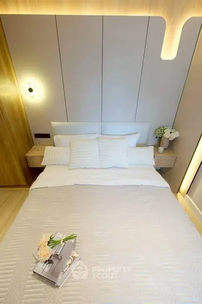 Modern bedroom with stylish lighting and cozy bedding in a contemporary apartment.
