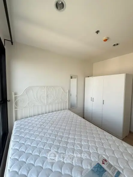 Bright bedroom with white wardrobe and elegant bed frame, perfect for a cozy retreat.