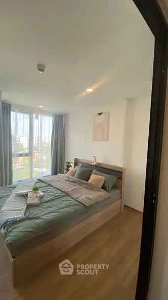 Cozy bedroom with modern decor and large window offering city view