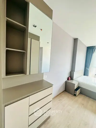 Modern bedroom with sleek furniture and large mirror in a bright apartment