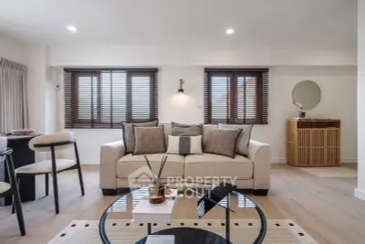 Modern living room with stylish decor and natural light, featuring a comfortable sofa and elegant furnishings.