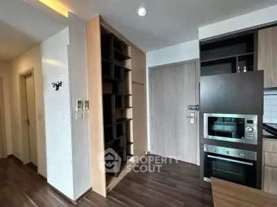 Modern apartment entrance with sleek kitchen and built-in storage