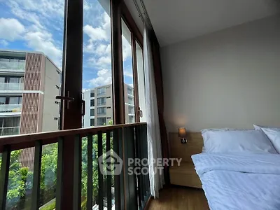 Modern bedroom with large windows offering a stunning view of contemporary buildings and lush greenery.