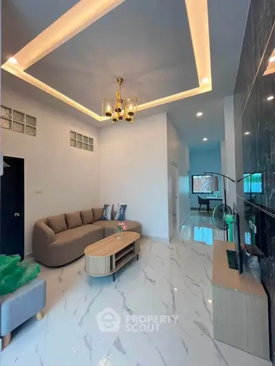 Modern living room with elegant lighting and marble flooring, featuring a cozy sofa and sleek TV setup.