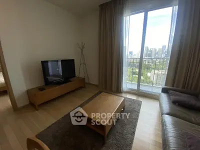 Modern living room with city view, featuring sleek furniture and large windows for natural light.