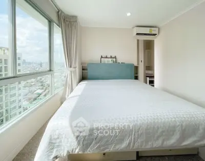 Spacious bedroom with city view and modern decor in high-rise apartment