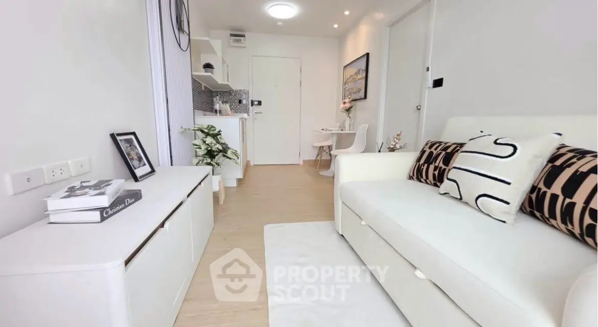 Modern living room with stylish decor and compact kitchen in open layout apartment.