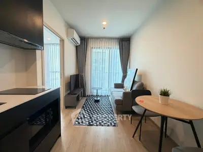 Modern living room with stylish decor and natural light, featuring a cozy sofa and sleek furniture.