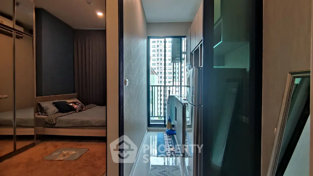Modern bedroom with balcony view in high-rise apartment, featuring sleek design and ample natural light.