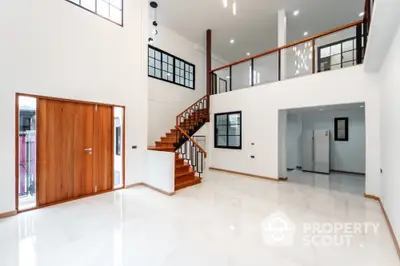 Spacious modern living room with mezzanine and elegant wooden staircase