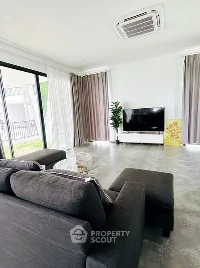 Spacious living room with modern decor and large windows for natural light.