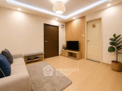 Modern living room with cozy decor and wooden flooring, featuring a TV unit and stylish lighting.