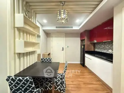 Modern kitchen with dining area, featuring stylish decor and wooden flooring.