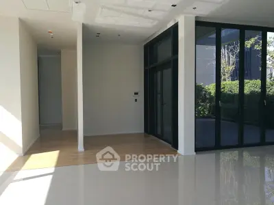 Spacious modern interior with floor-to-ceiling windows and garden view, perfect for natural light lovers.