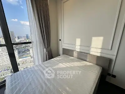 Luxurious bedroom with stunning city view and elegant decor in high-rise apartment.