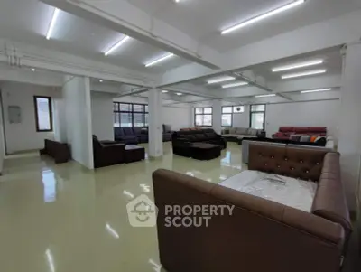 Spacious living room with modern sofas and ample natural light, perfect for relaxation and entertaining.