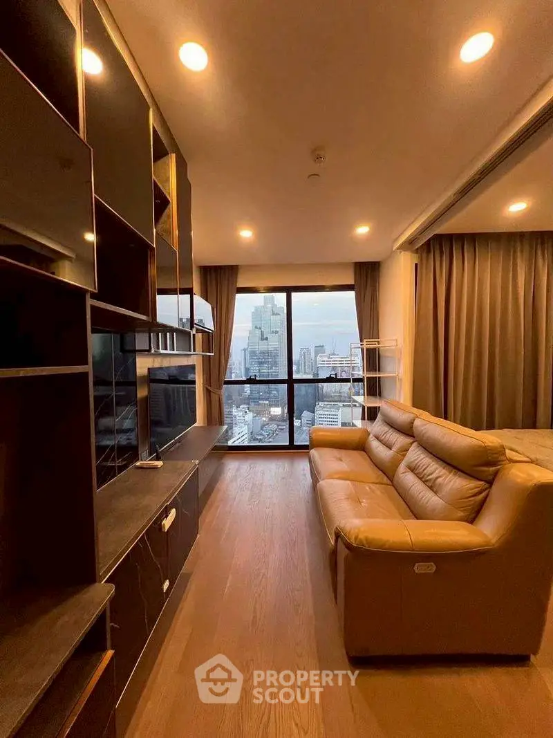 Modern living room with city view, featuring sleek shelving and comfortable leather sofa.